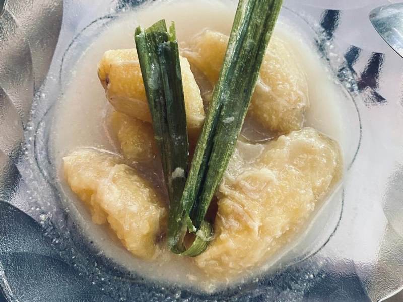 Semangkuk kolak pisang dengan potongan ubi jalar oranye dalam kuah santan gula merah.